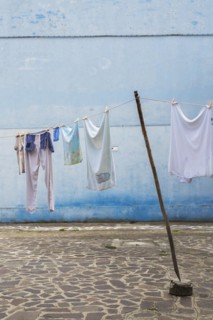 Washed clothes on clothesline in residential backyard with flagstones, Burano Island, Venetian