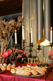 A beautifully arranged dessert table displays a variety of pastries, fruits, and decorative