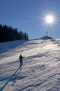 Nice and active senior woman snowshoeing in in the Allgau alps above Immenstadt, Bavaria, Germany
