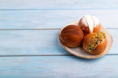 Maritozzo traditional Italian bun dessert on blue wooden background with, copy space, side view