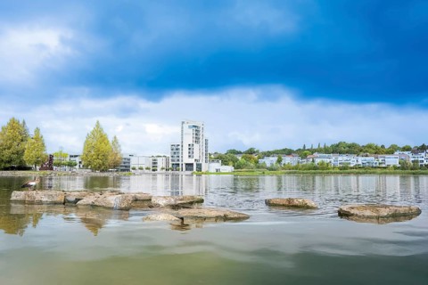 Phoenix Lake Dortmund, foreground water and the typical stone slabs or rocks, background houses,
