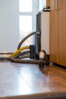 Professional water damage repair Drying equipment and hoses for underbody drying on wooden floor