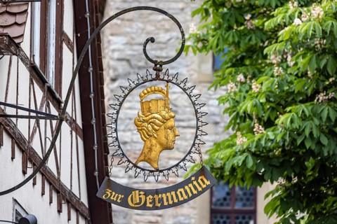 Nose sign of the former pub Zur Germania. Town view of Schwäbisch Hall, Baden-Württemberg, Germany