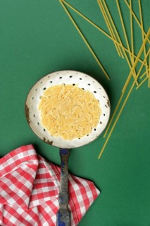 Semi di orzo in sieve ladle, pasta variety in the form of cereal grains and spaghetti