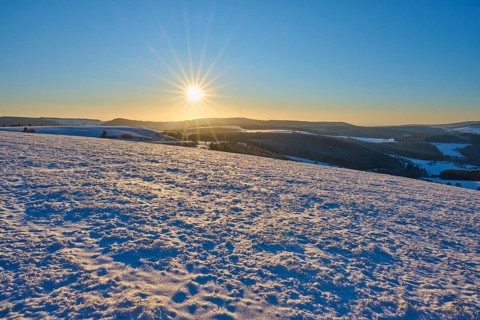Winter landscape with snow-covered hills and bright sun on the horizon, Winter, Wasserkuppe,