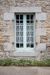 Classic French lattice window with light blue shutters in rustic country style, Roscoff, Finistère,