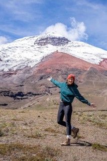 Women poses in front of the Cotopaxi volcano, Cotopaxi, Cotopaxi National Park, Latacunga, Ecuador
