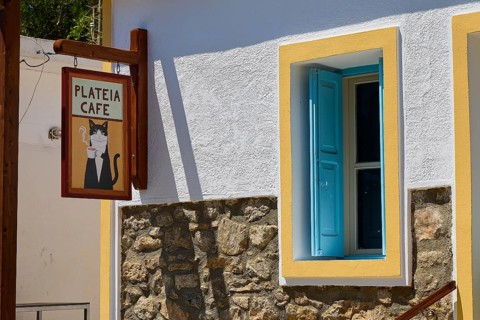 Cosy café with wooden sign and colorful window frames in quiet surroundings, Megalo Chorio, Zero