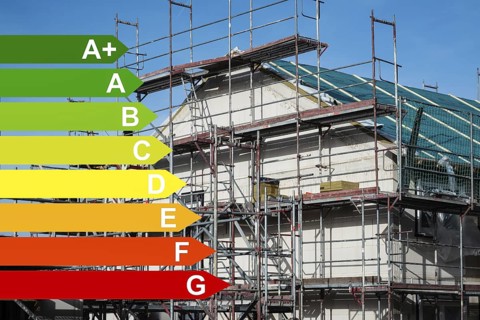 Scaffolding in front of a new insulated detached house, graphics with energy efficiency classes