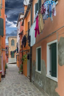 Colourful houses with laundry on the line in an alley on Burano, Venice, Veneto, Italy