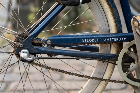 Close-up of a blue bicycle frame with the brand name Veloretti-Amsterdam and rear wheel, Nørreport,