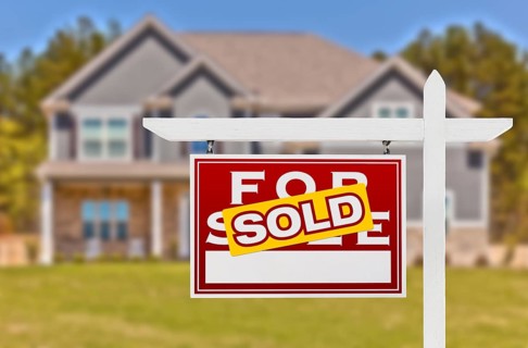 Sold Home For Sale Real Estate Sign in Front of Beautiful New House