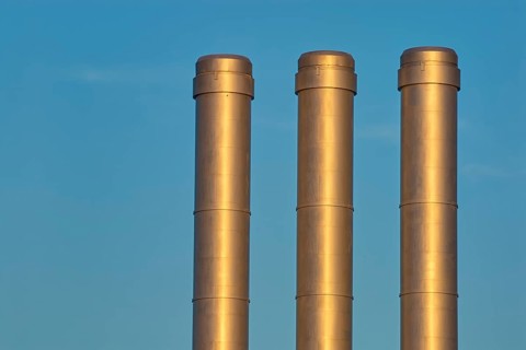 Three golden industrial chimneys in front of a clear blue sky, Würzburg, Mainfranken, Bavaria,