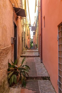 View through a picturesque narrow alley of the medieval old town of Cervo, province of Imperia,