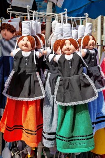 Rag dolls in traditional Breton clothes in various colors, Traditional dolls on a market in