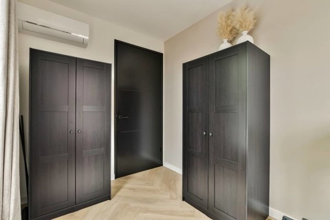A sleek and contemporary interior space featuring dark cabinets, a minimalist design, and a neutral