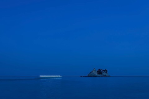 Blurry boat lights flowing by night to the island Sveta Nedjelja in Montenegro.