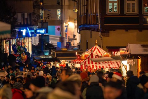 Festive night market with a crowd and illuminated market stalls in the town, Christmas market Calw,