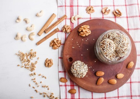 Energy balls cakes with almonds, sesame, cashew, walnuts, dates and germinated wheat on wooden