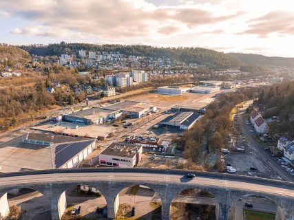 Industrial area and viaduct in front of wooded hills and cloudy sky, Nagold, Black Forest, Germany
