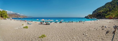 Panoramic view of Apella beach, with parasols and blue sky, Apella beach, Karpathos, Greece