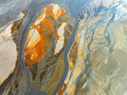 Top view abstract of a winding river cutting through sandy textures, revealing a stunning fusion of