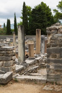 Old stone wall structure with door step, marble and granite columns at ancient 3rd century Roman