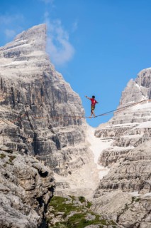 Slackliner in the mountains, mountain peaks of the Brenta Mountains, at Refugio Francis Fox
