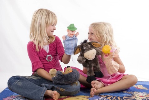 Two blonde girls, 6 and 7 years old, playing with hand puppets, Punch and Judy, figures, theatre,