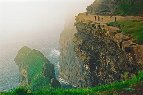 People on the edge of a cliff, there was no fence back then, Cliffs of Moher, County Clare,