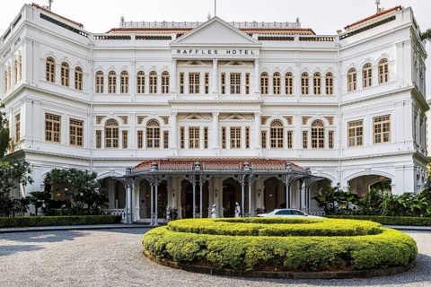 Colonial era Raffles Hotel opened by the Sarkies Brothers in 1887 fronts a manicured courtyard