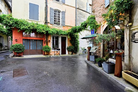 Green house facades in a district street in the city, Arles, Camargue, southern France, France