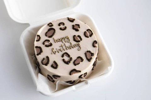 Top view of a stylish bento birthday cake with a leopard print pattern and a golden Happy Birthday