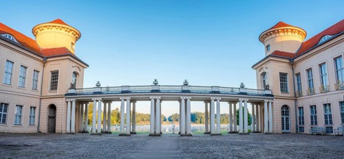 In the inner courtyard of Rheinsberg Castle, view through the arcades of the colonnade to the Lake
