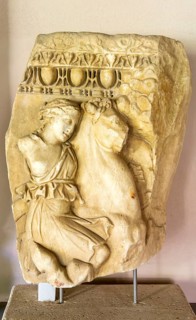 Fragment of Roman carved marble sarcophagus, female amazon on battle horse, archaeology museum,
