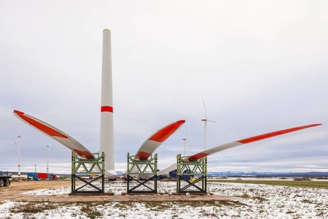 Rotor blades lying in front of the unfinished tower at the Cramme wind farm construction site,