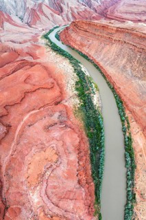 Aerial view of the Rio San Juan curving through dramatic red-and-orange canyon landscapes in Utah,