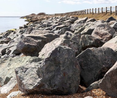 Rock armour coastal defences against erosion, East Lane, Bawdsey, Suffolk, England, UK