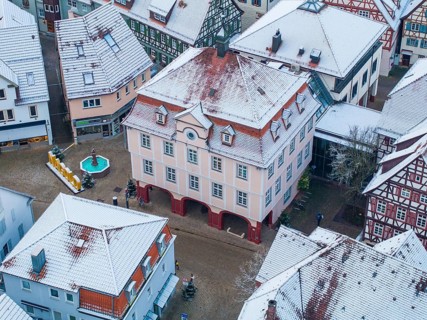 Historic building in winter with snow-covered roofs and a small square, Nagold, Black Forest,