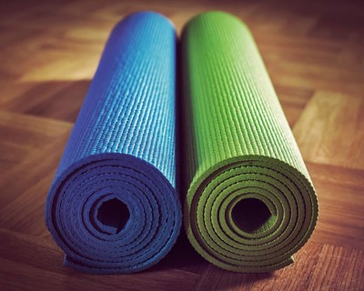 Vintage retro effect filtered hipster style image of Yoga mats on wooden floor