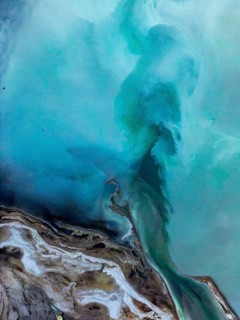 Aerial view of a vibrant geothermal landscape near Rotorua, New Zealand, showcasing dynamic shades