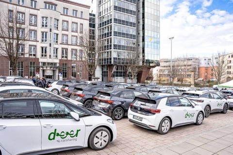 Cars in a parking lot surrounded by multi-storey buildings in the city, Deer, E-Carsharing,
