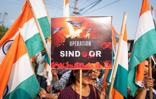 People holding Indian national flags as they take part in a rally, in soliderity with the Indian