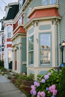 A vibrant scene from St. John's, Newfoundland, showcasing a row of colorful Victorian houses with