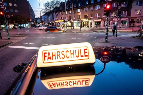 Symbolic picture of driving school, evening trip in the city center, urban traffic