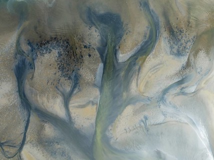 Streams and marshes at low tide in the wetlands of the Walvis Bay lagoon. In the distance Greater