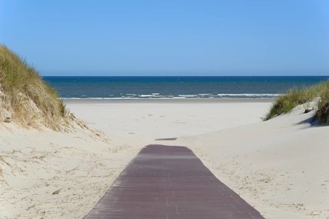 Boardwalk leads through the dunes to the extensive sandy beach, blue sky, North Sea, Juist, East