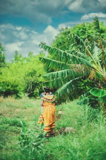 Young farm workers walking through a plantain harvest. Two peasant girls walking through a plantain