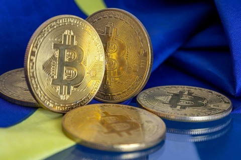 Close-up of symbolic bitcoins with an EU flag