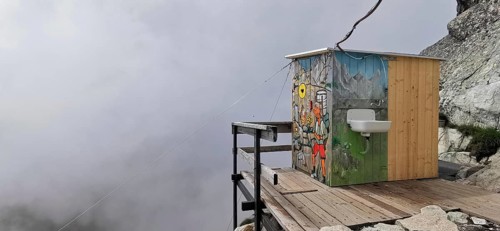 Toilet of a mountain hut, Chata pod rysmi, colorful wooden hut on a terrace with fog in the